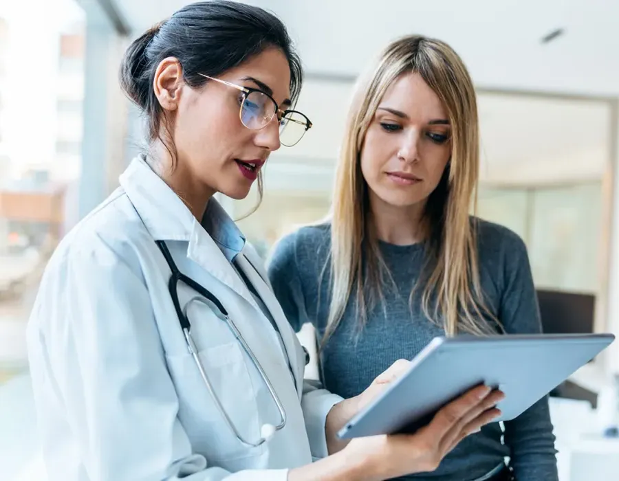 Women's health nurse practitioner reviewing test results with female patient